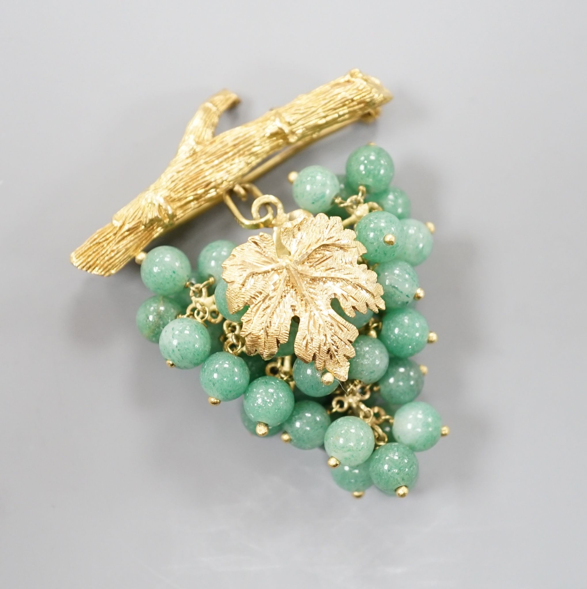 A 20th century continental 18k yellow metal and adventurine quartz bead set brooch, modelled as a bunch of grapes hanging from a branch, 59mm, gross weight 30.4 grams.